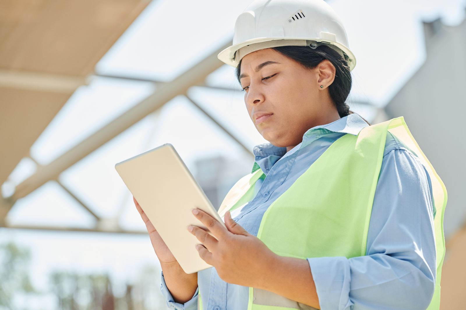 Construction engineer using a tablet during a field inspection