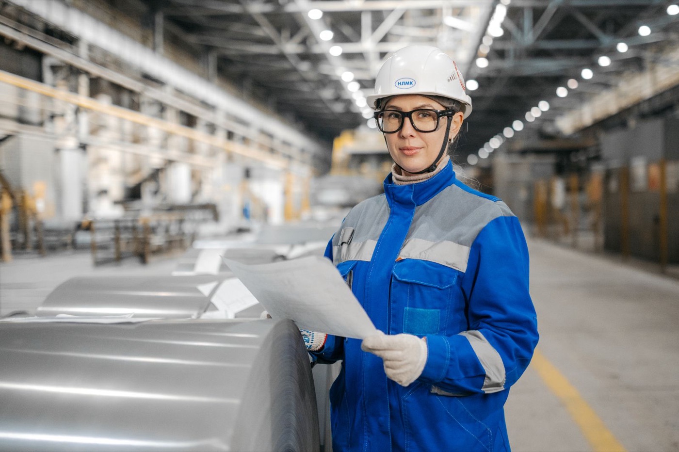 Industrial service engineer reviewing equipment inspection documents inside a factory