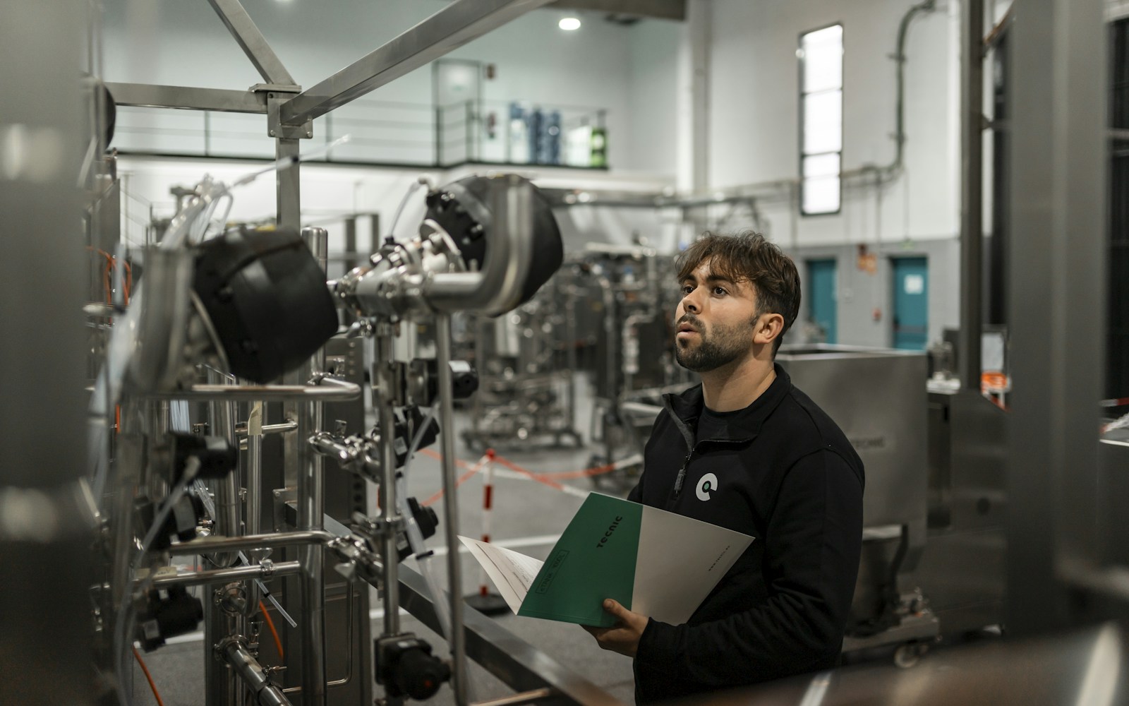 Field service technician inspecting industrial HVAC equipment with documentation
